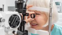 Woman undergoes eye test on slit lamp